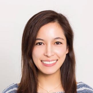 Stephanie Tong smiles at the camera wearing a blue and white striped sweater