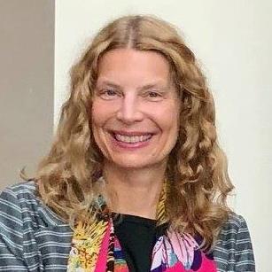 Susan C Herring smiles at the camera wearing a floral scarf